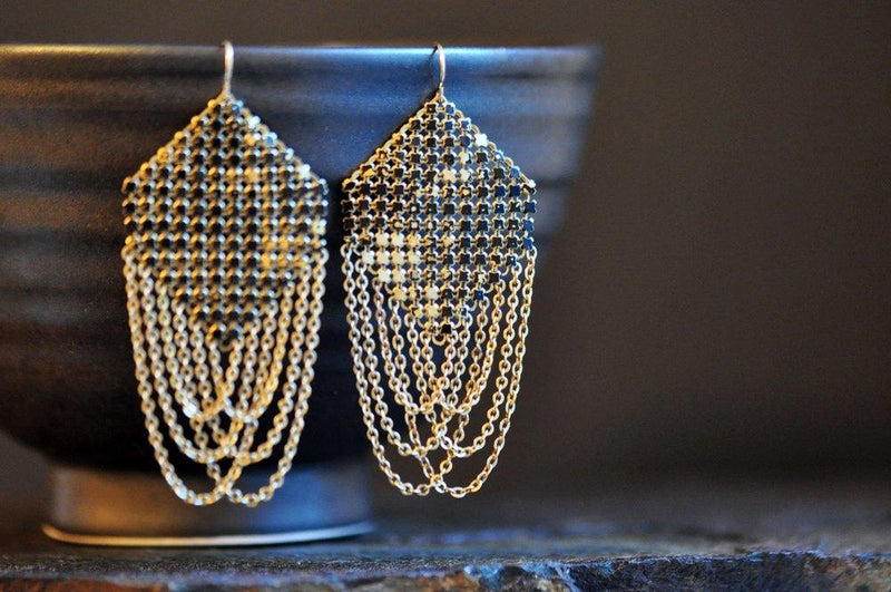 Lifestyle view of Swagged Lantern Mesh Earrings in Faded Black, handmade by Maral Rapp with enamel metal mesh recycled from an antique mesh purse. 